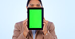 Portrait, tablet and green screen mockup with an asian woman in studio on a blue background for website promotion. Tech, space or chromakey and a person holding a display with tracking markers