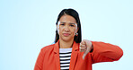 Portrait, woman and thumbs down with rejection, no and feedback on a blue studio background. Face, girl and model with facial expression, hand gesture and review with complaint, opinion and decision
