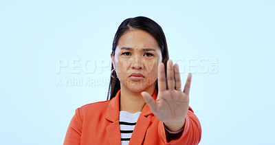 Buy stock photo Hand, stop sign and portrait of woman in a studio with mad, upset and angry facial expression. Activism, protest and Asian female person with an open palm gesture isolated by blue background.