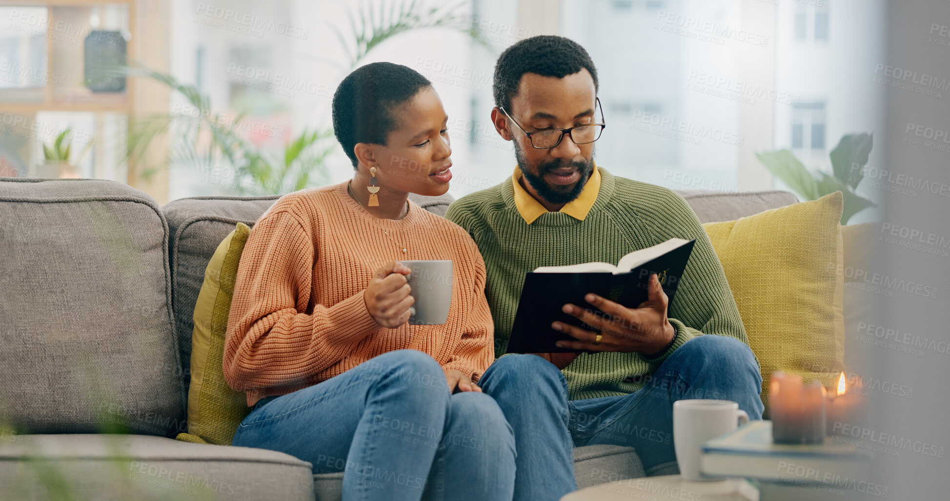 Buy stock photo Home, relax and black couple on a couch, bible and reading with religion, love and bonding together. Romance, apartment or man with woman, scripture and holy book with Christian, hope or conversation
