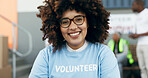 Volunteer woman, portrait and happy for charity, clothes drive and community service with kindness at desk. African girl, ngo and social responsibility with donation boxes, care or smile for helping