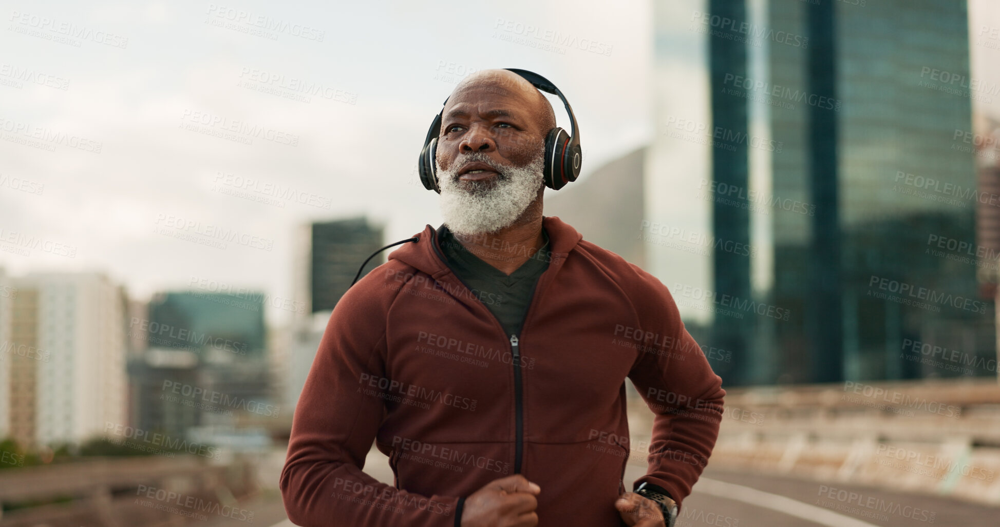 Buy stock photo Mature, athlete and running in city with headphones for fitness, workout or marathon training music. Black man, thinking or exercise podcast in South Africa for cardio wellness, health or sport radio