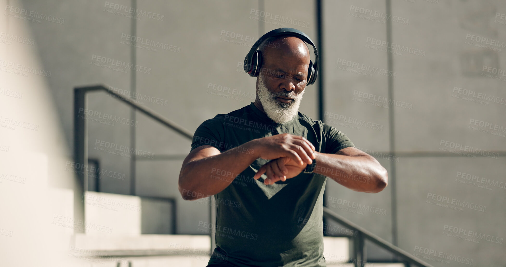 Buy stock photo Fitness, headphones and black man on smart watch in city, workout progress and exercise results for body health. Music, senior athlete and check time on clock, heart rate and serious in town on steps