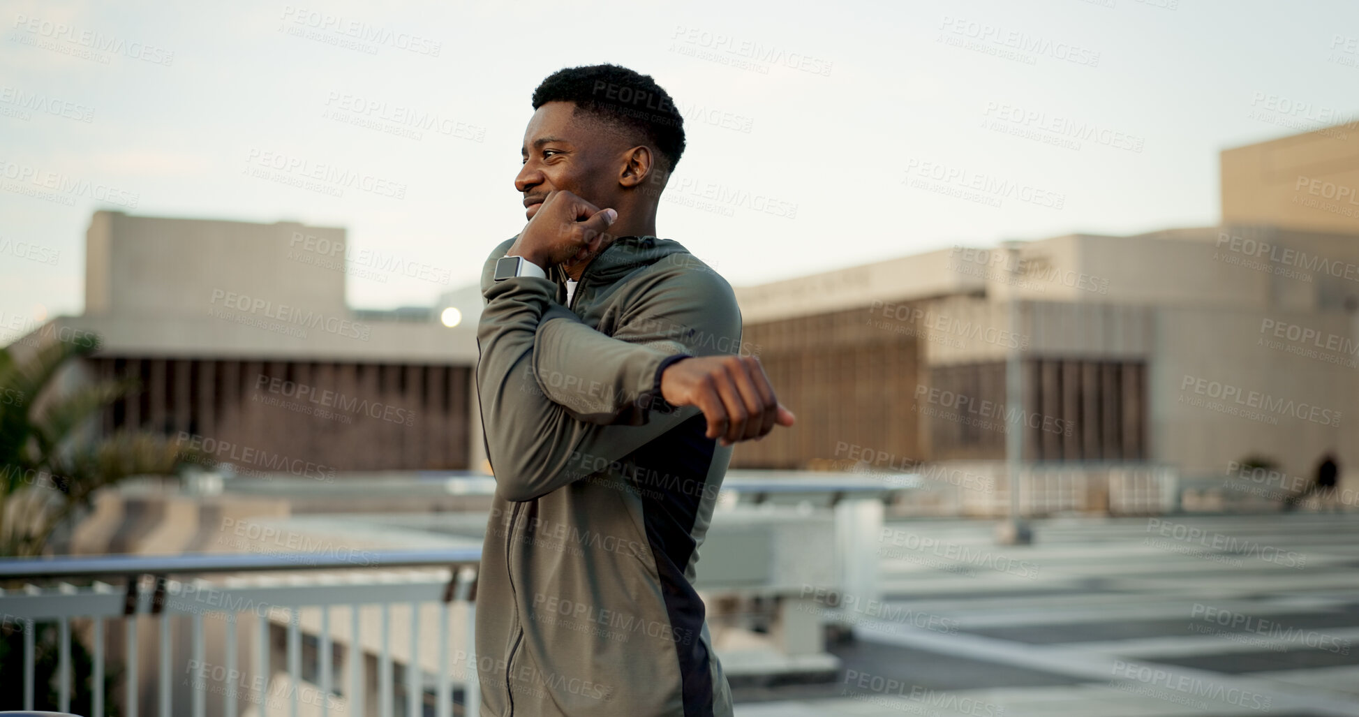 Buy stock photo Black man, fitness and stretching on rooftop in city for workout, training or outdoor exercise. Happy African male person, runner or athlete in body warm up or arm stretch getting ready in urban town