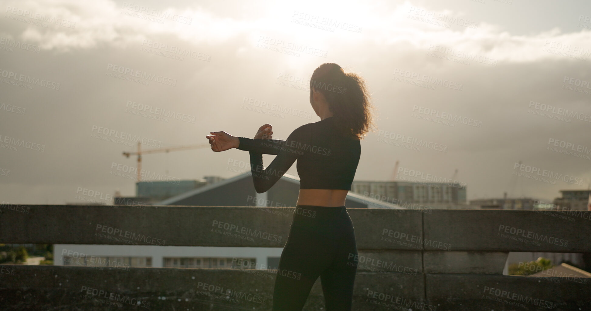 Buy stock photo Woman, stretching and fitness in city for workout, exercise or outdoor training in sunset. Rear view of female person, runner or athlete in body warm up or arm stretch getting ready in an urban town