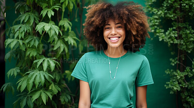 Buy stock photo Portrait of young female, wearing a green t-shirt against a plant wall for eco friendly concept