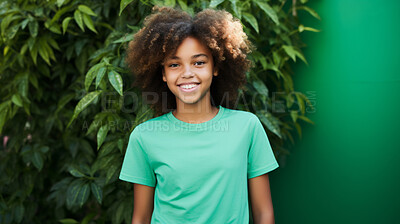 Portrait of young happy female, wearing a green t-shirt against a plant wall for eco friendly