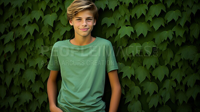 Portrait of young male, wearing a green t-shirt against a plant wall for eco friendly concept