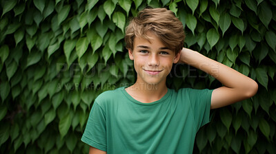 Buy stock photo Portrait of young male, wearing a green t-shirt against a plant wall for eco friendly concept