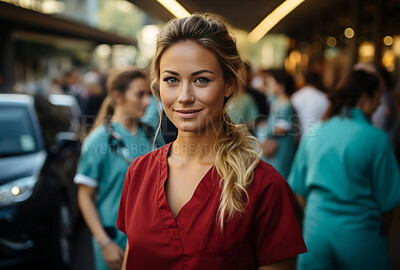 Portrait of young nurse. Smiling at camera outside of hospital. Medical staff concept.