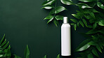 White blank hairspray container on a green leafy backdrop. For organic or eco friendly product