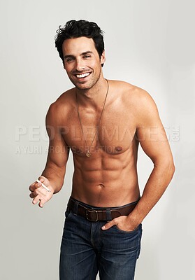 Buy stock photo A shirtless young man standing with his hand in his pocket and smoking