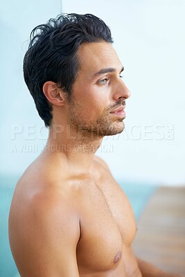 Buy stock photo Profile of a handsome young man with tattoos sitting with his back against a pane of glass