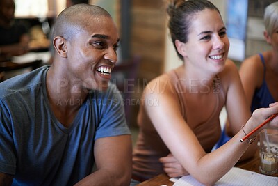 Buy stock photo Cropped shot of two young friends studying together at a coffee shop