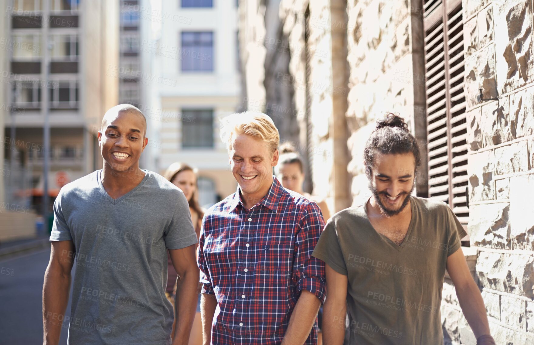 Buy stock photo Cropped shot of three young men walking around town