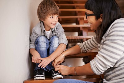 Buy stock photo Learning, tying and shoes with mother and kid for child development, bonding and helping. Happy, smile and support with woman and young boy on steps in family home for laces, care and happiness