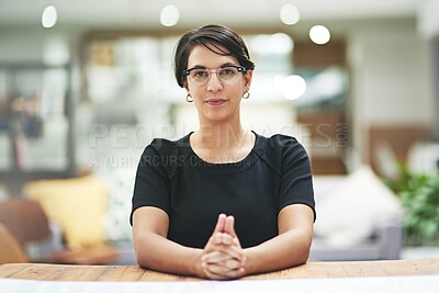 Buy stock photo Cropped portrait of a young businesswoman sitting at her desk in her office