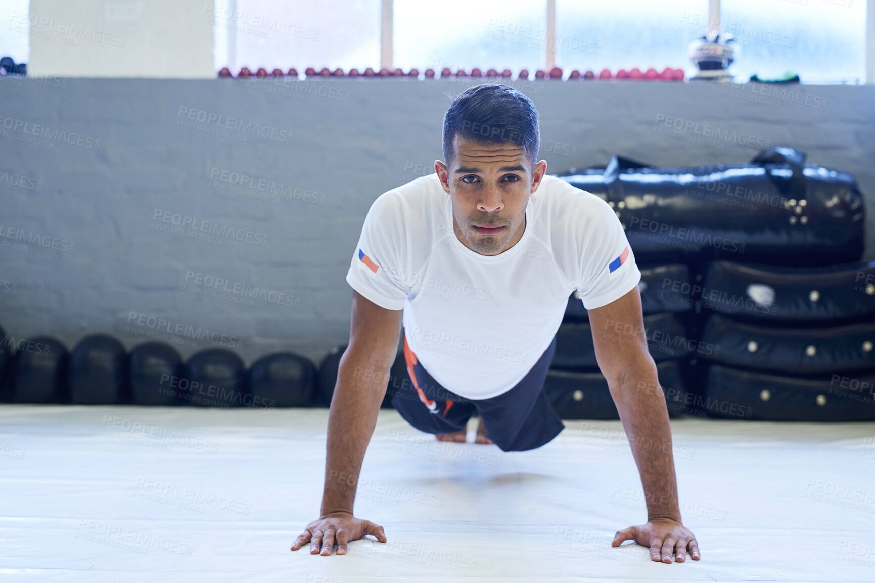 Buy stock photo Portrait of a young man doing pushups in the gym