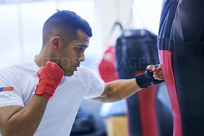 Buy stock photo Shot of a young man going through his boxing routine in the gym