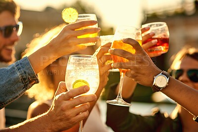 Buy stock photo Cropped shot of a group of unrecognizable friends having a drink and spending the day outside on a rooftop