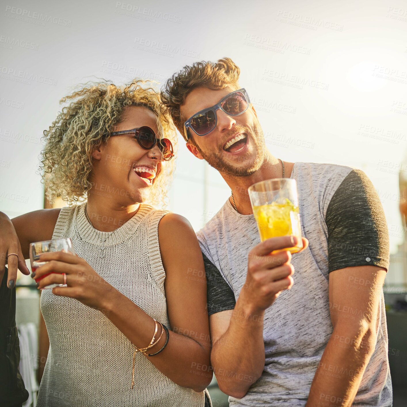 Buy stock photo Cropped shot of an attractive young couple having a drink and spending the day outside on a rooftop