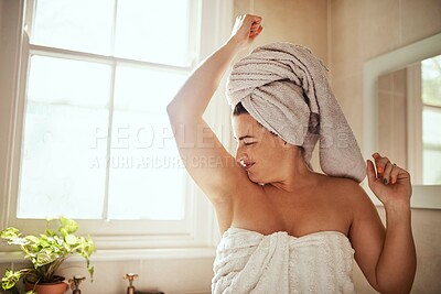 Buy stock photo Shot of an attractive young woman smelling her armpits during her morning beauty routine