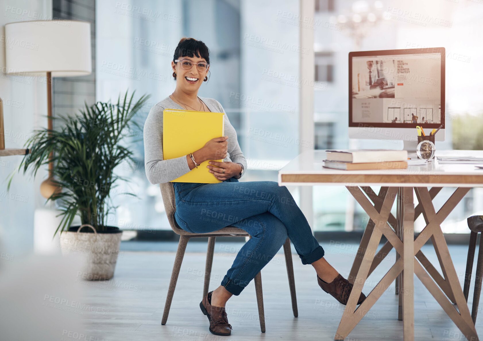Buy stock photo Full length portrait of an attractive young businesswoman sitting alone and holding files in her office