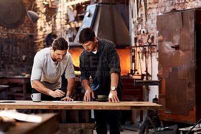 Buy stock photo Cropped shot of two handsome young businessmen working together inside their workshop