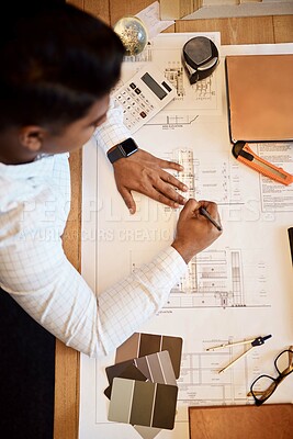 Buy stock photo High angle shot of an architect using a ruler to draw a building plan