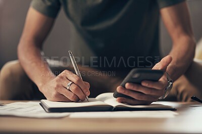 Buy stock photo Shot of an unrecognisable man using a smartphone while going through paperwork at home
