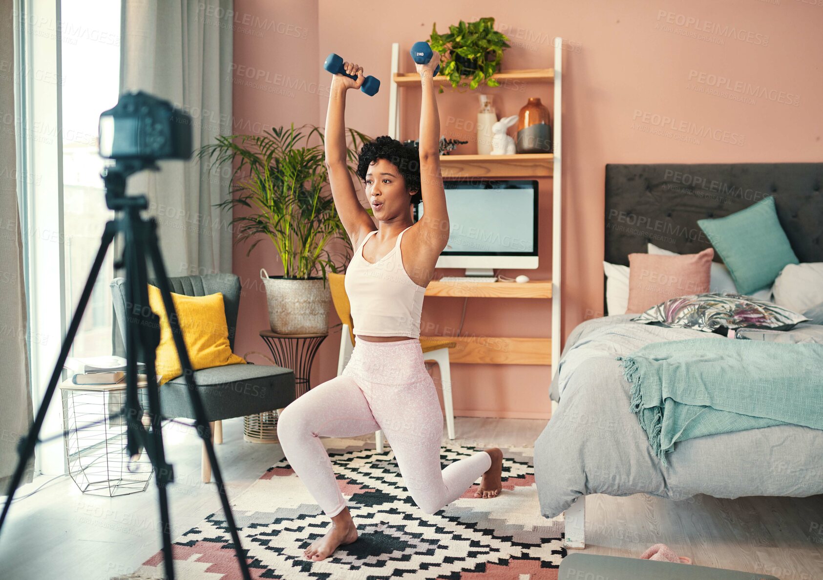 Buy stock photo Shot of a young woman recording herself while exercising at home