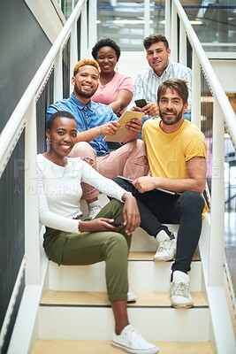 Buy stock photo Portrait of a group of confident young businesspeople sitting on the steps of a modern office