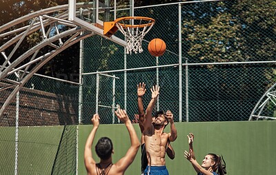 Buy stock photo Shot of a group of sporty young people playing basketball on a sports court