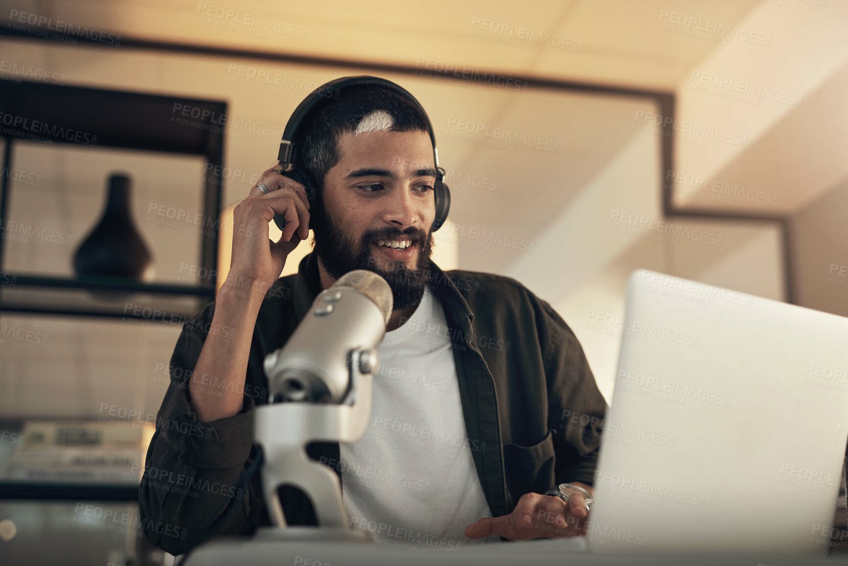 Buy stock photo Shot of a young man using a headset, microphone and laptop during a late night at work