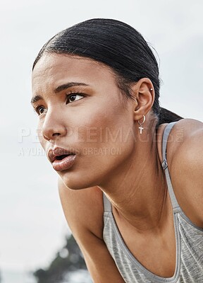 Buy stock photo Shot of a young woman catching her breath while exercising outdoors