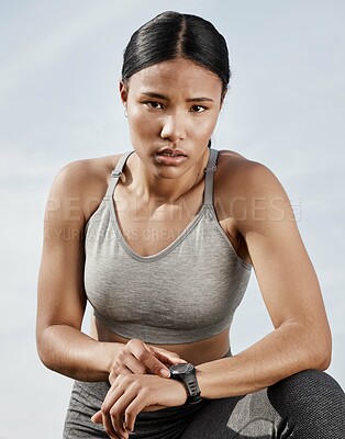 Buy stock photo Shot of a sporty young woman checking her smartwatch while exercising outdoors