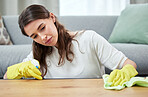 Woman, cloth and gloves for cleaning wood table with spray, chemical or hygiene in home living room. Girl, cleaner and services with ppe, fabric and product for dust, shine and stop bacteria in house