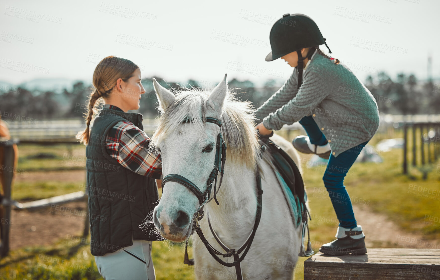 Buy stock photo Child, horse and learning during a lesson with a woman about horseback riding with help on a farm. Helping, support and coach teaching girl kid with animal for sports physical activity in countryside