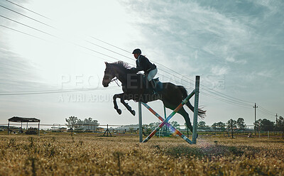 Buy stock photo Woman on horse, jumping and equestrian sports practice for competition with blue cloudy sky on ranch. Training jump, jockey or rider on animal for racing on obstacle course, dressage or hurdle race.