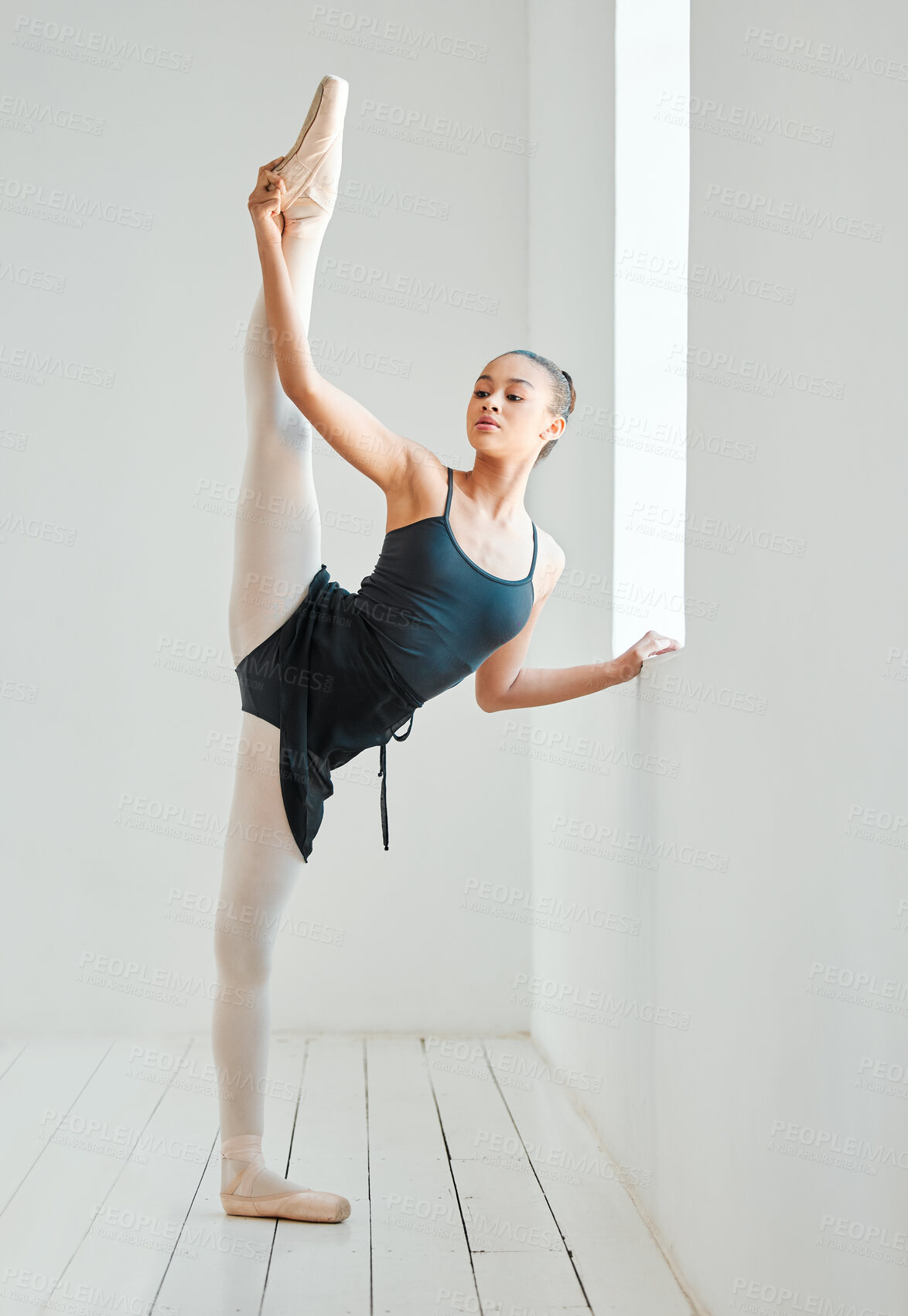 Buy stock photo Ballet, woman and leg stretching by window, class and training in dance studio, fitness and exercise. Female person, dancer and strong or flexible, performance and graceful or balance technique