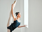 Ballet, woman and leg stretch by window, class and training in studio, fitness and exercising. Black female person, dancer and strong or flexible, performance and graceful or balance technique
