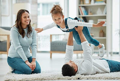 Buy stock photo Shot of a young family playing together at home