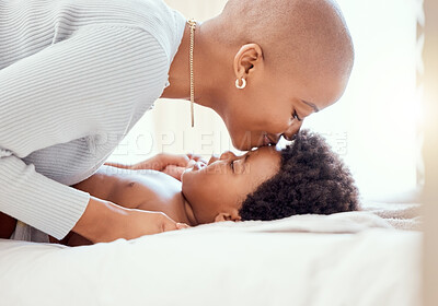 Buy stock photo Love, bonding and mother kissing baby on a bed relaxing and playing together in nursery at home. Happy, maternal and young African mom with little newborn, child or kid in bedroom at modern house.