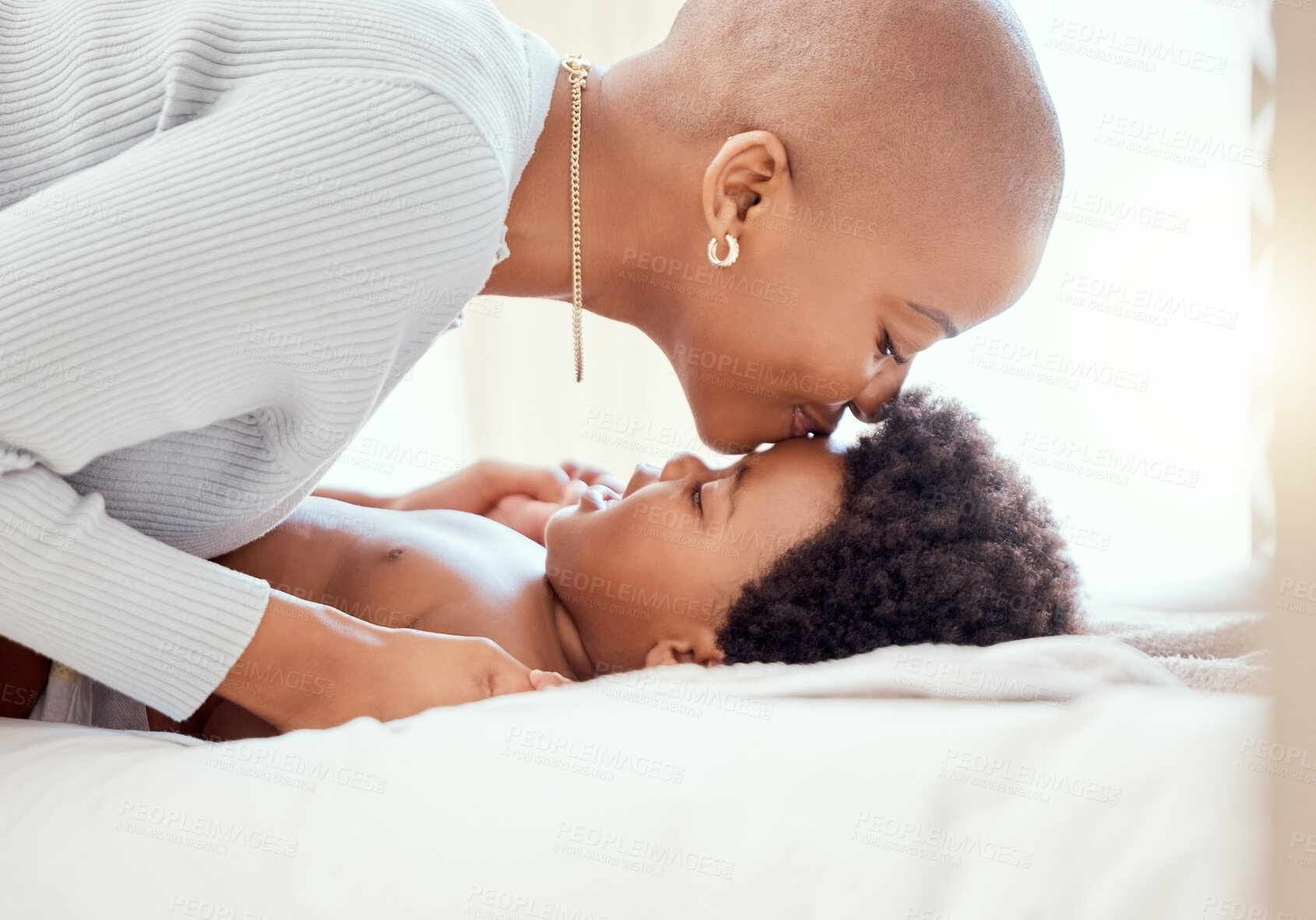 Buy stock photo Love, bonding and mother kissing baby on a bed relaxing and playing together in nursery at home. Happy, maternal and young African mom with little newborn, child or kid in bedroom at modern house.