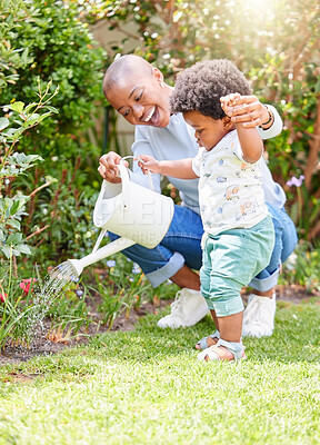 Buy stock photo Mother watering, walking and baby on garden grass with black family, gardening and support together with child in summer. Lawn, relax and mom with happy kid and backyard with mama and water in nature