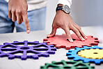 Closeup, business and teamwork with gears, employee and collaboration with engineering, problem solving and ideas. Person, hands or professional with research, development or cooperation with project