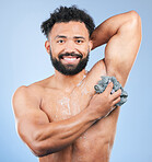 Shower, washing and portrait of man with sponge for cleaning, soap hygiene and skincare on blue background. Dermatology, bathroom and person with splash, foam and cosmetics for wellness in studio