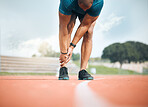 Exercise, running and ankle pain with a sports person holding their leg closeup on a race track outdoor. Fitness, training and the legs of an athlete with a joint injury at a stadium or venue