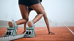 Woman, feet and starting blocks as runner on sports track field for morning challenge, marathon practice or action cardio. Black person, legs and position for ready go race, back view or performance