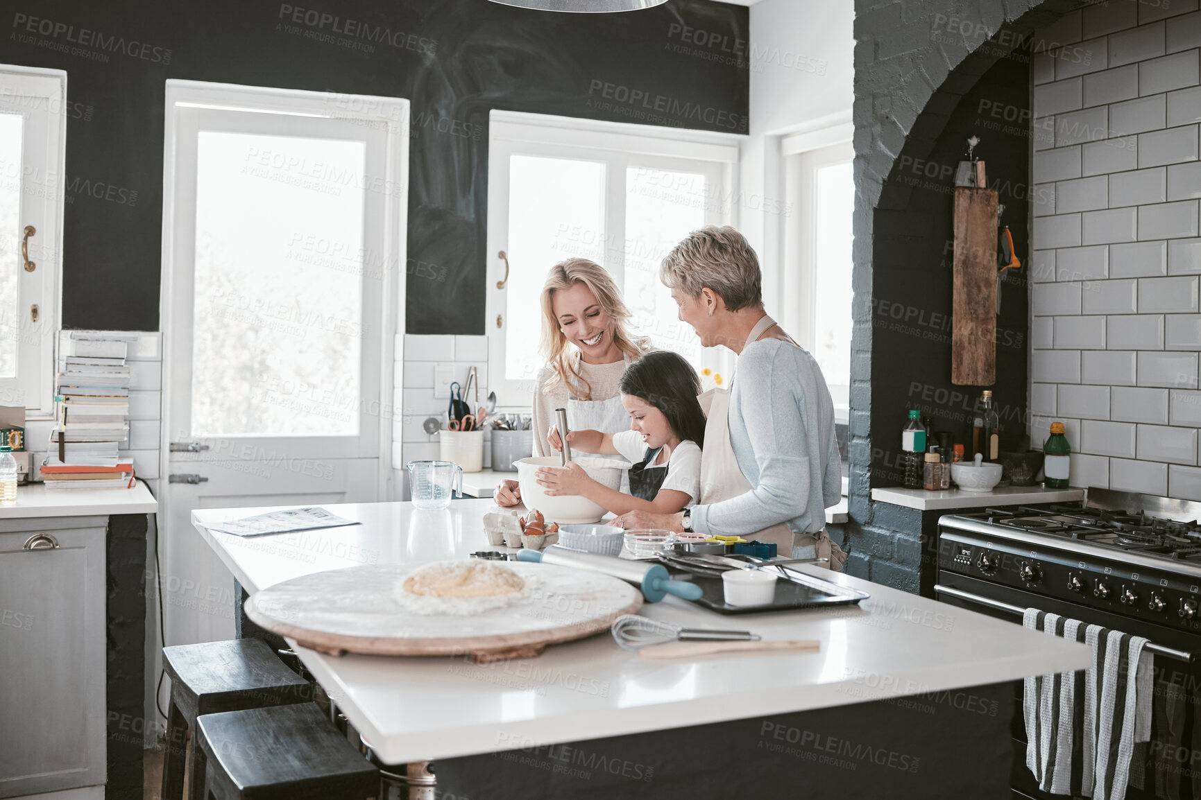 Buy stock photo Grandmother, mother and child baking in the kitchen together while bonding in the family home. Senior woman, mom and girl kid cooking food for dinner or lunch for party, celebration or event at house